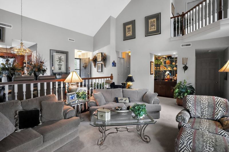 Vaulted living room with tall windows, sofas and the stone fireplace