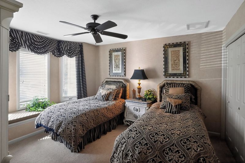 Twin suite with two twin beds, window seat and ceiling fan